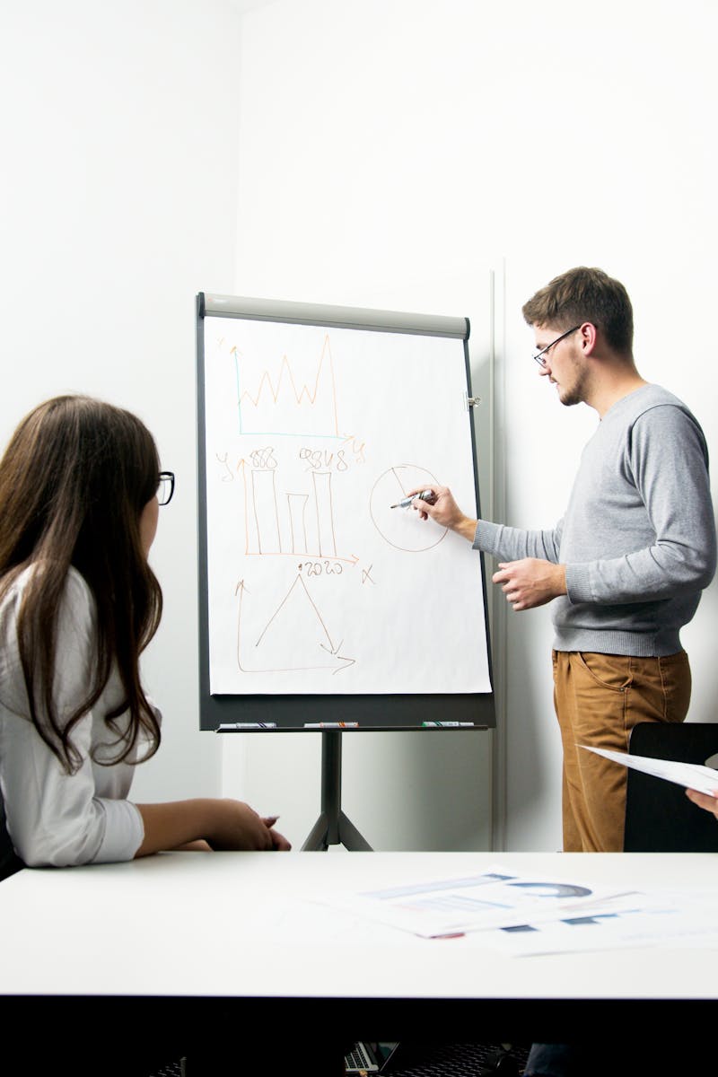A businessperson giving a presentation with charts in a modern office environment.
